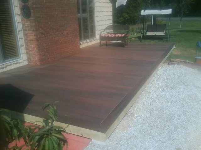 Freshly stained wood deck built against a brick home in Elmer