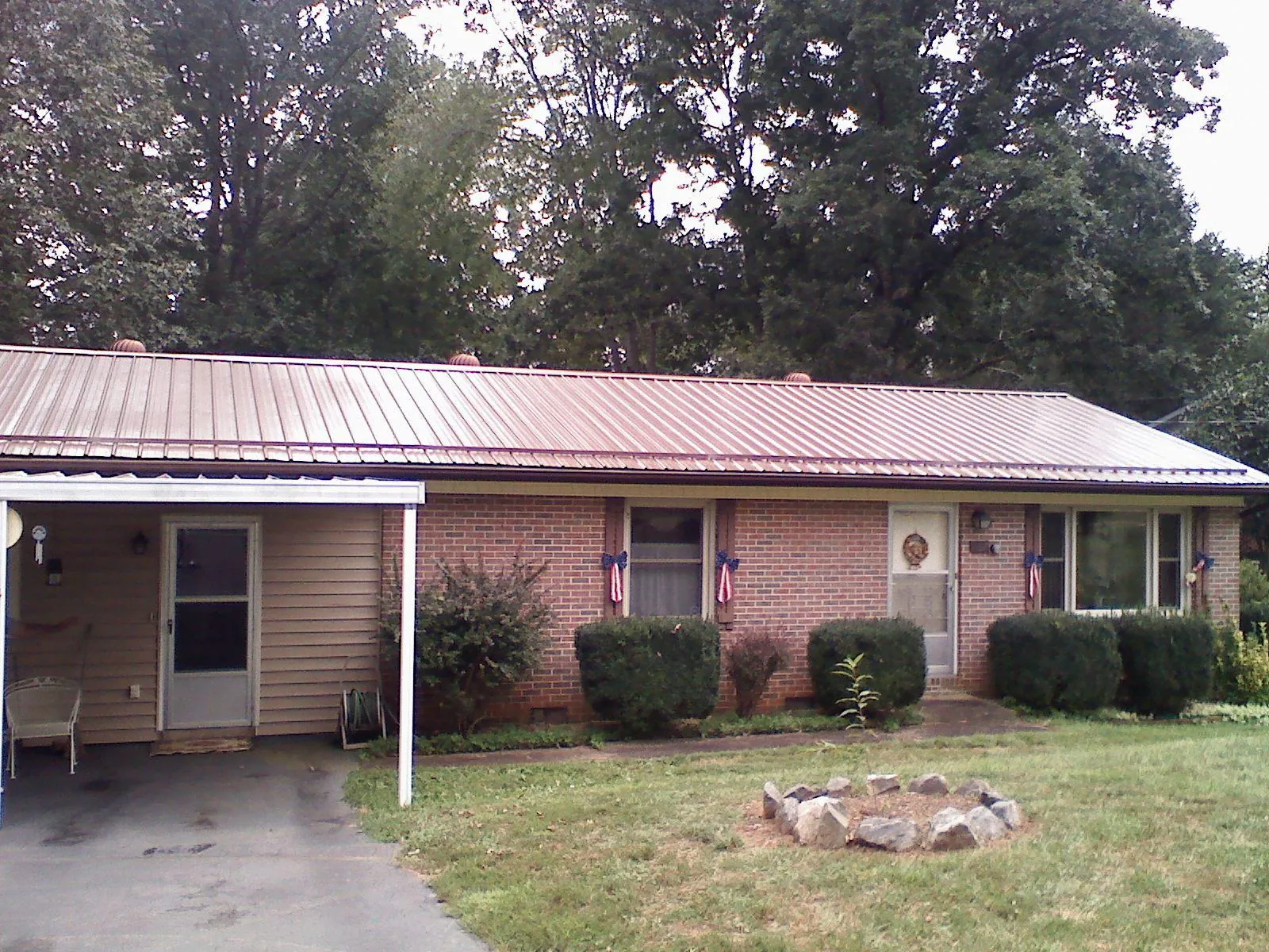 Bronze metal roof and carport on a brick ranch home — Roof Repair work by our crew in Elmer