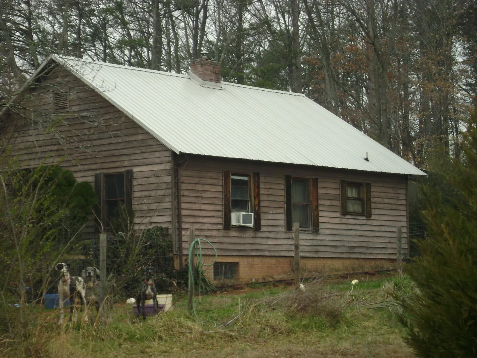 White metal roof on an old wood sided farmhouse, from a Metal Roof Installation job in Elmer